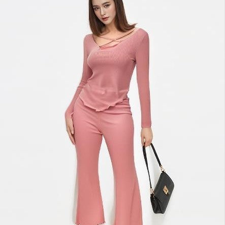 Model wearing a solid color pajama set in soft pink, featuring a stylish top and comfortable pants, perfect for lounging.