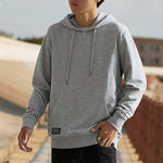 Person wearing a gray hoodie with a blurred background