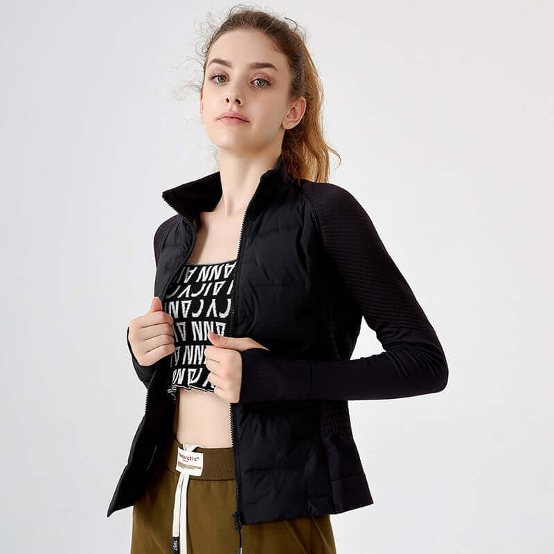 Woman wearing a black jacket over a black crop top with white text on a light gray background