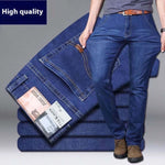 Stack of blue jeans with a person wearing them, on a gray background