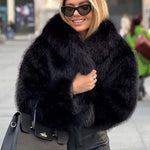 Woman wearing a stylish plush winter coat for women, smiling in a city setting, with sunglasses and a handbag.