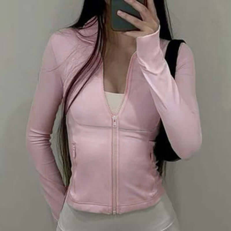 Person wearing a pink zip-up jacket taking a mirror selfie.