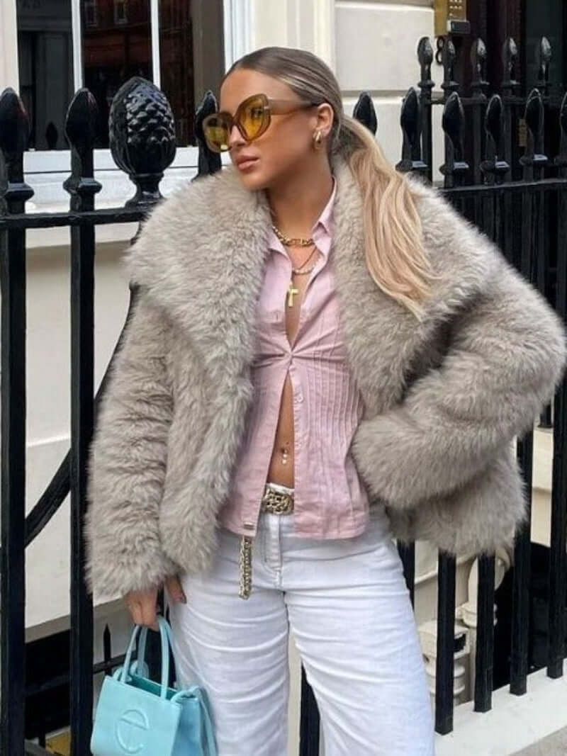 Woman wearing a plush winter coat for women with fluffy lapel, styled with a pink top and sunglasses.