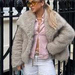 Woman wearing a plush winter coat for women with fluffy lapel, styled with a pink top and sunglasses.