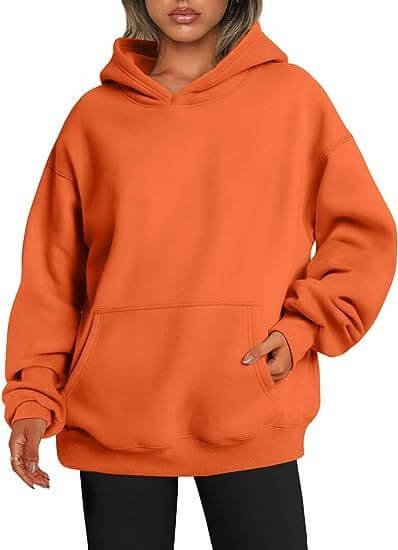 Orange hoodie worn by a person on a white background