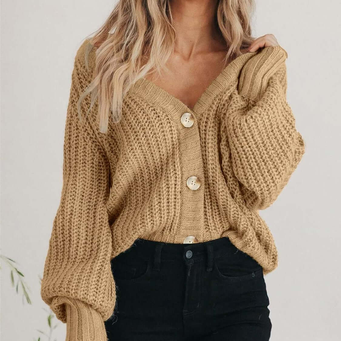 Women’s thick knitted cardigan sweater in beige with buttons and long sleeves, ideal for cold weather.