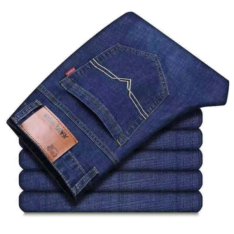 Stack of folded blue jeans with a brand label on a white background