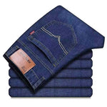 Stack of folded blue jeans with a brand label on a white background